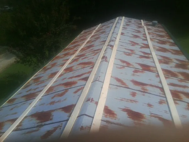 Rusted metal roof panels with new wood purlins before replacement — Storm Damage Roof Repair in Meansville by Roofing Brothers