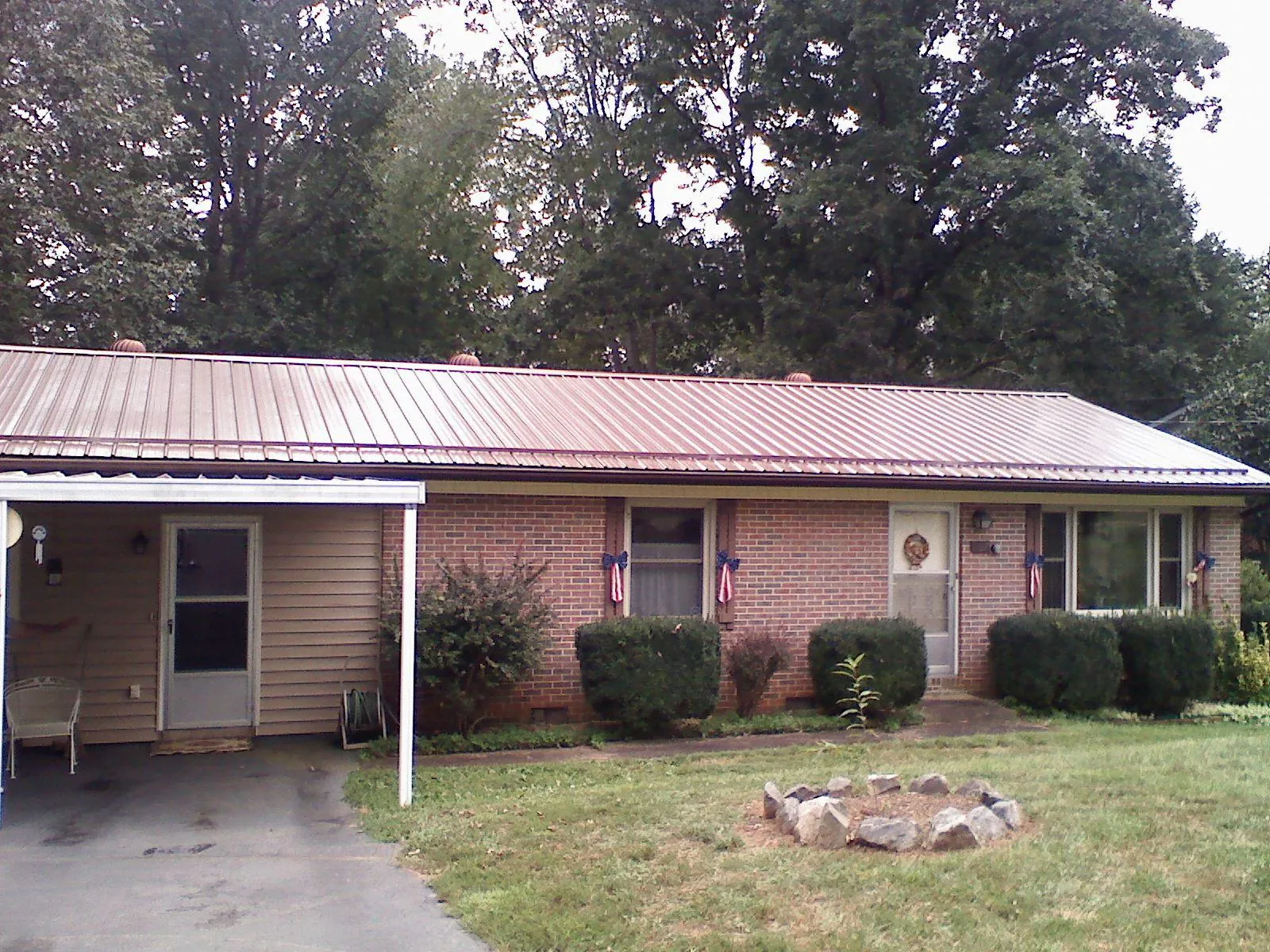 Bronze metal roof and carport on a brick ranch home — Roof Repair work by our crew in Meansville