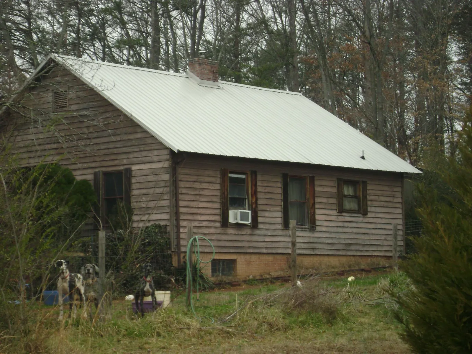 White metal roof on an old wood sided farmhouse, from a Metal Roof Installation job in Meansville